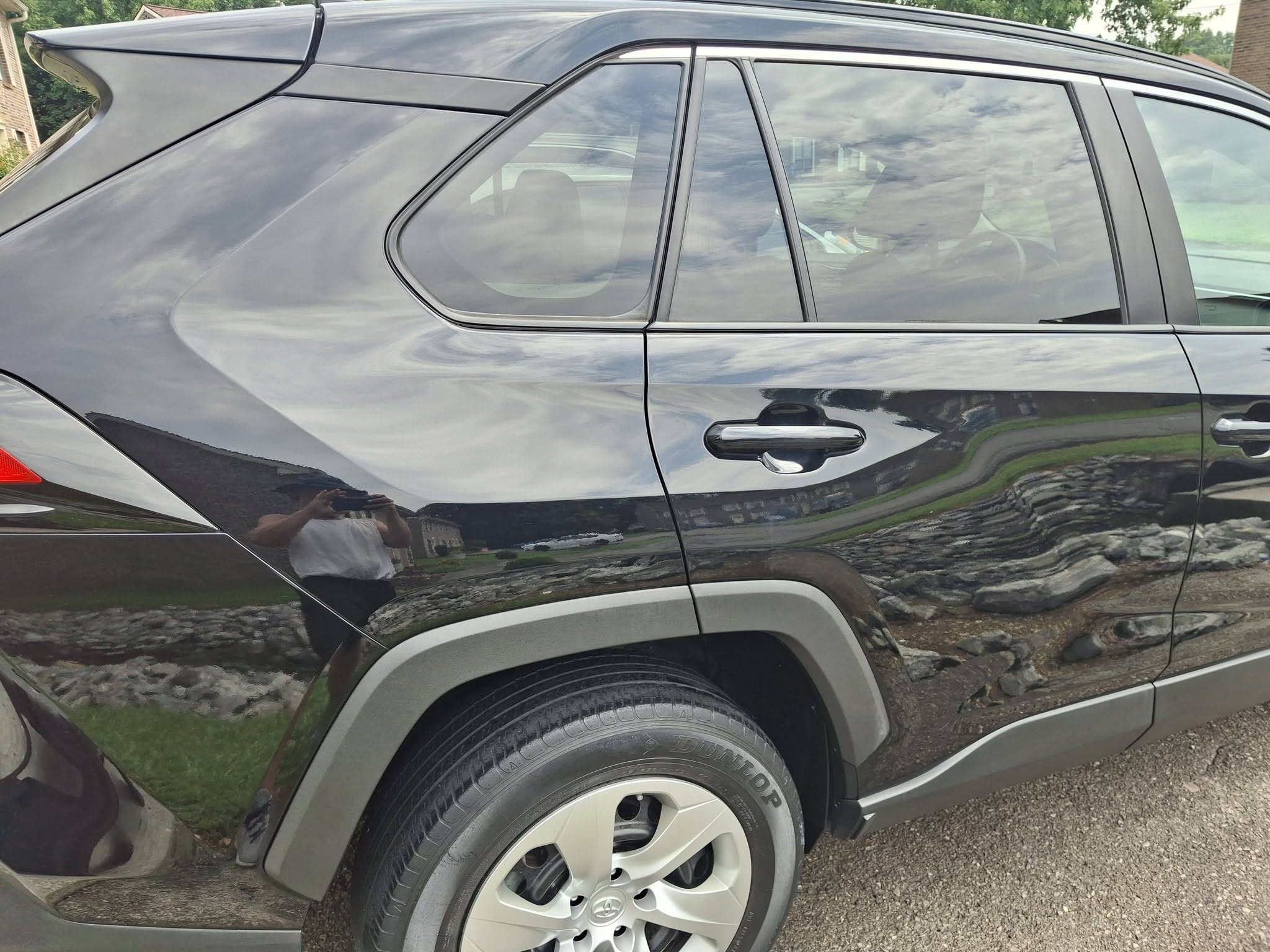 Mirror-finish reflections down the side of a black RAV4